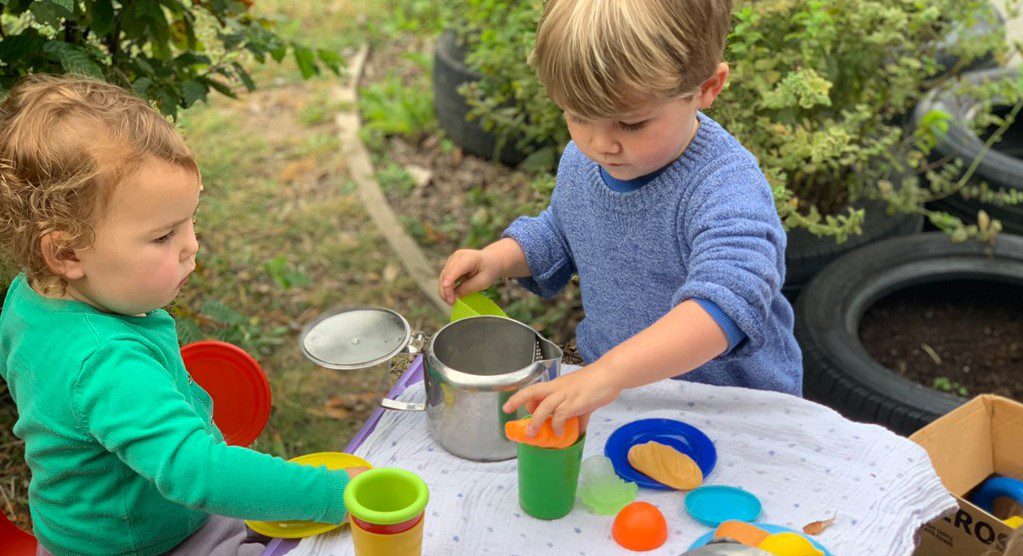 toddlers playing with a teaset