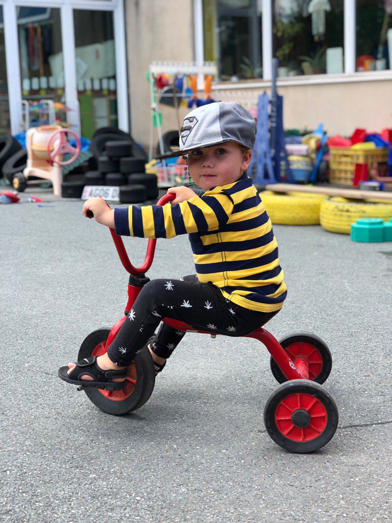 child on tricycle in playground at preschool