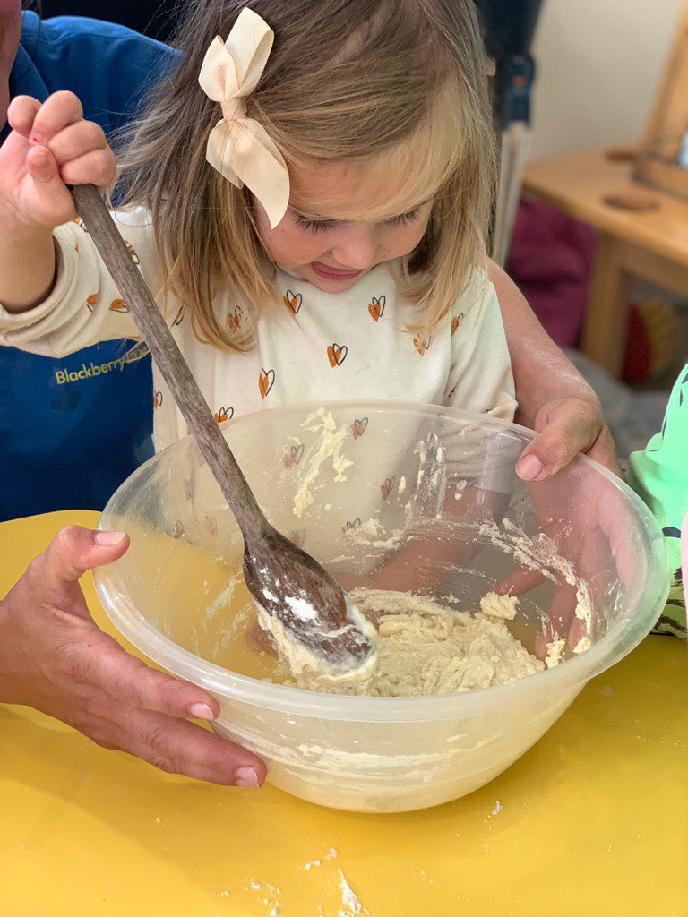 small child mixing batter with spoon