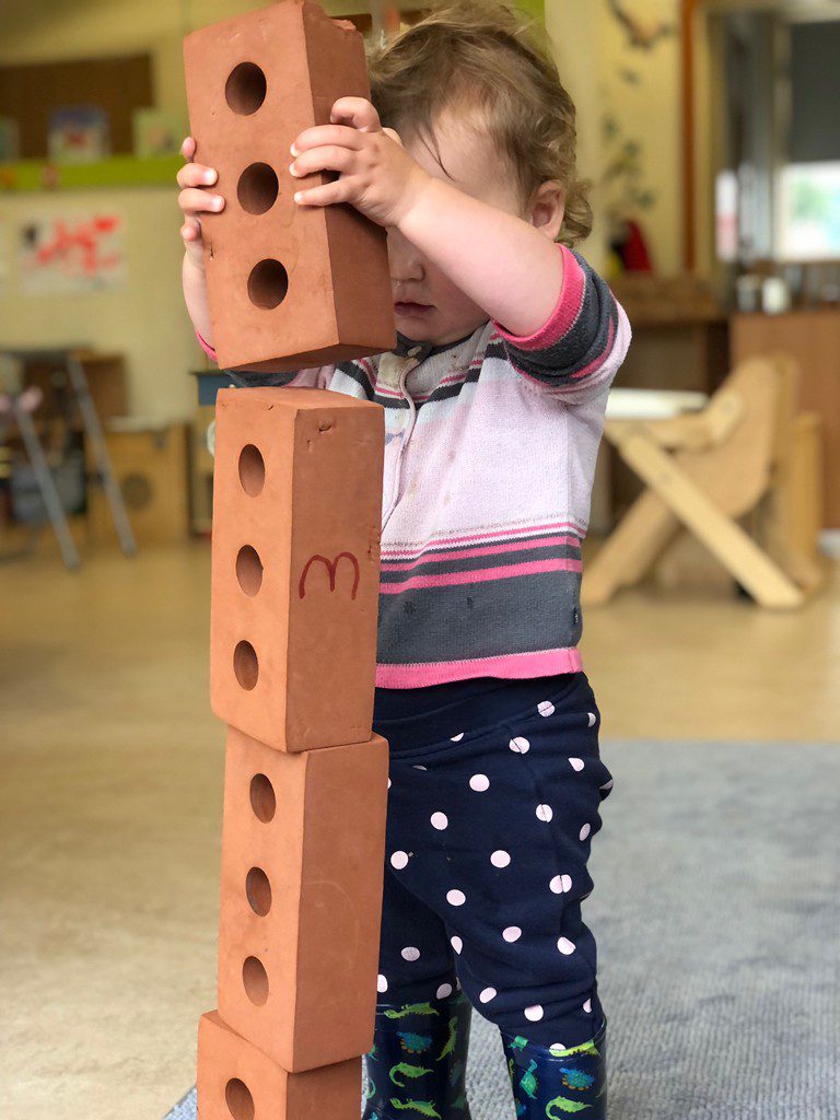 toddler building a tower with bricks