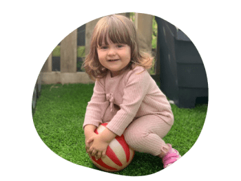 toddler playing with a stripy ball