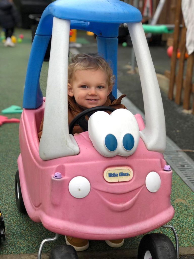 toddler driving pink toy car