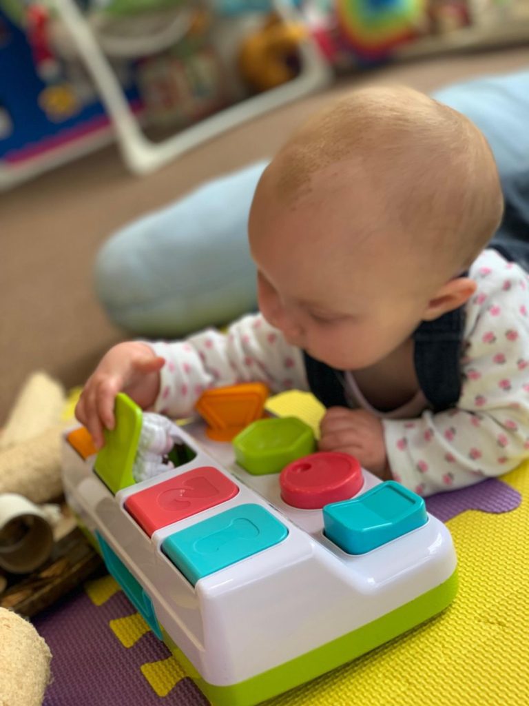 baby playing with pop up toy