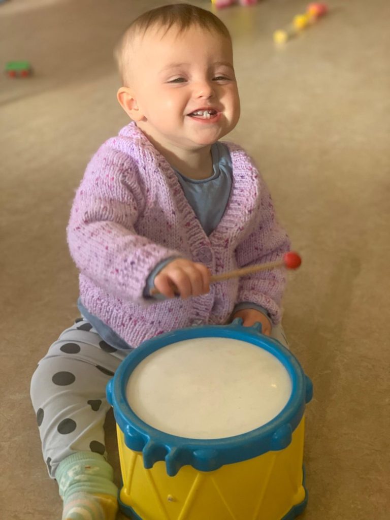 baby playing with toy drum