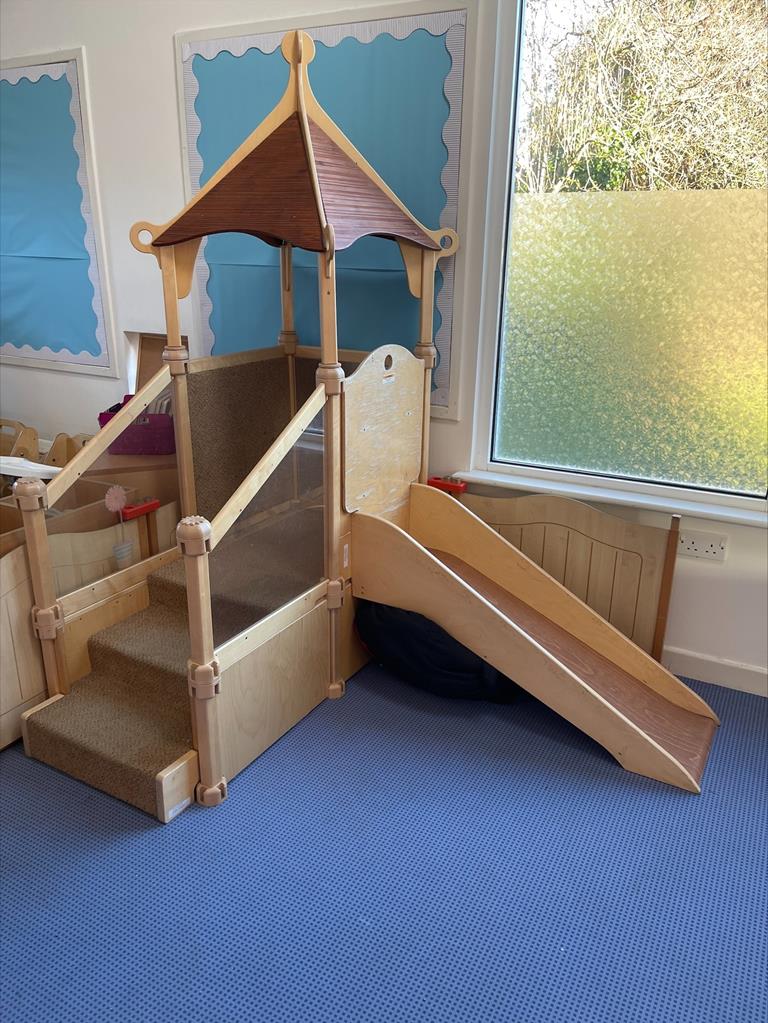 Nursery room, with small indoor wooden slide for toddlers.